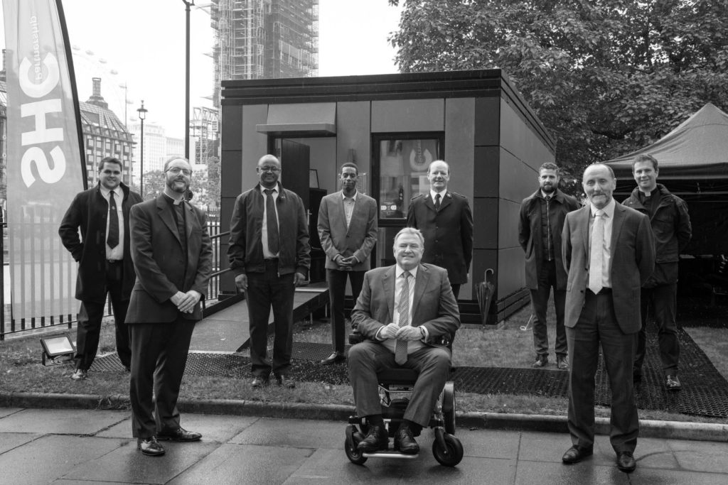 From left to right: Captain John Clifton, The Reverend Anthony Ball, Emmanuel Gotora, Stephen Serrant, Andy Hill, Lieutenant Colonel Drew McCombe, Tom Hill, Eddie Hughes MP, The Reverend Dr James Hawkey