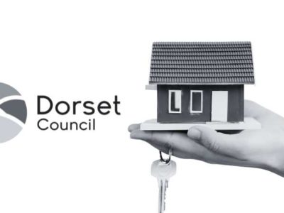 Image shows the Dorset Council Logo alongside a small miniature property held in a hand with a set of keys.