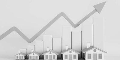 Black and white photo showing a graphic indicating house prices increasing.