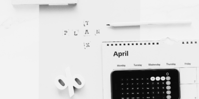 Black and white image of an Iphone calculator and folder stating tax plan.