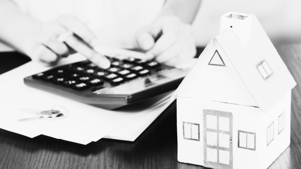 Black and white image of house and calculator with files