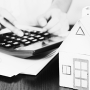 Black and white image of house and calculator with files