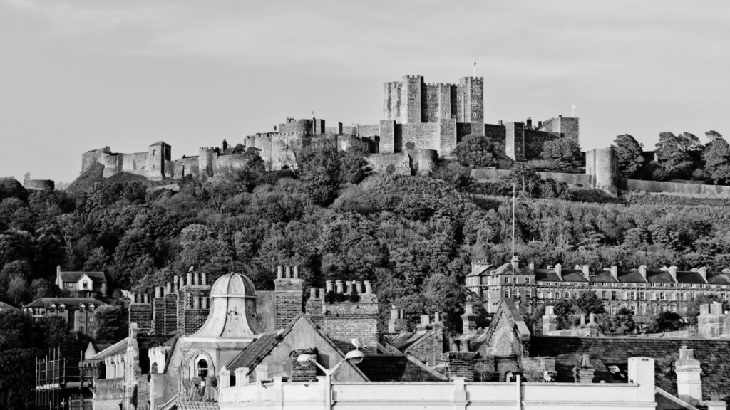 Black and white image of kent with houses and castle on a hill