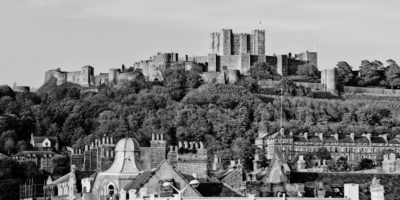 Black and white image of kent with houses and castle on a hill