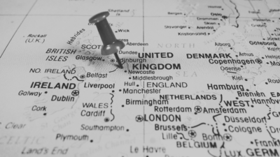Black and white image of UK Map with pin