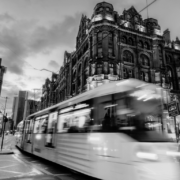Black and white image of Manchester city centre with tram