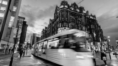 Black and white image of Manchester city centre with tram