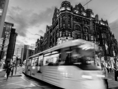 Black and white image of Manchester city centre with tram