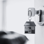 Black and white door open with metal house keyring and key in latch.
