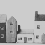 A black and white image of handpainted house models of different sizes.
