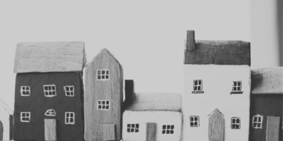 A black and white image of handpainted house models of different sizes.