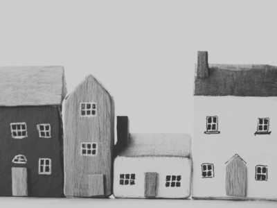 A black and white image of handpainted house models of different sizes.