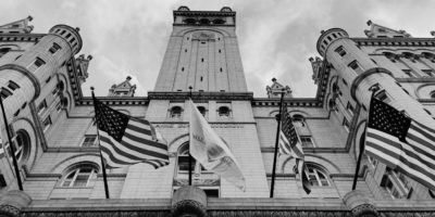 Black and white image of government building with american flags