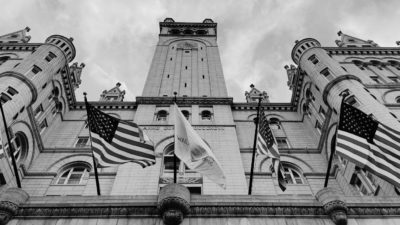 Black and white image of government building with american flags