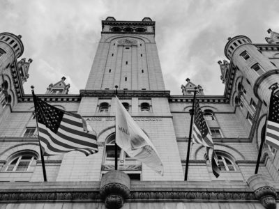 Black and white image of government building with american flags