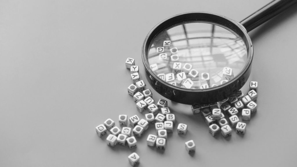 Magnifying glass over scrambled letters