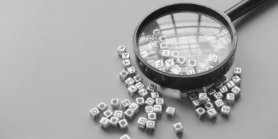 Magnifying glass over scrambled letters