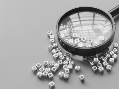Magnifying glass over scrambled letters