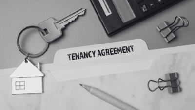 Tenancy agreement file with a keyring of a house in black and white and paper pins