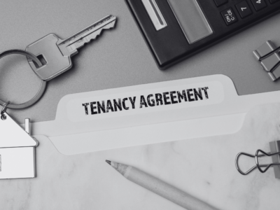 Tenancy agreement file with a keyring of a house in black and white and paper pins