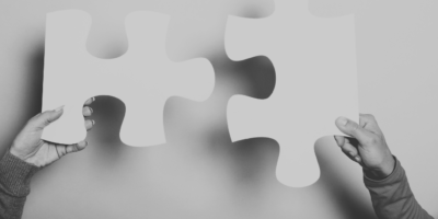 Jigsaw piece fitting together with hands