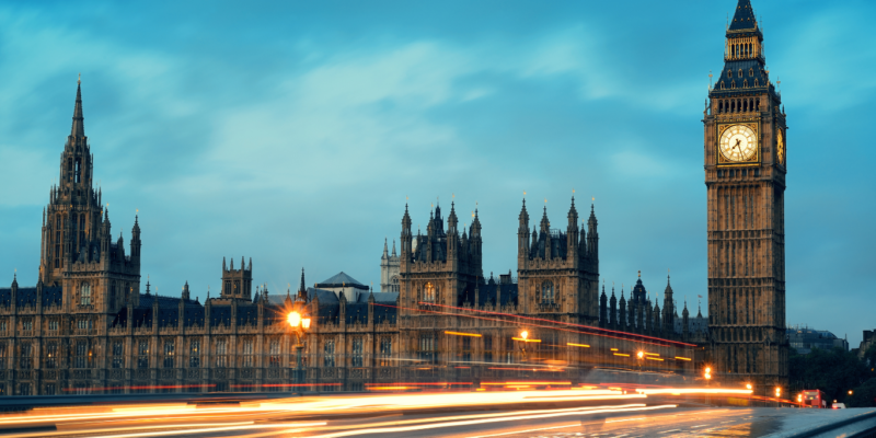 UK Government panoramic view with moving cars in a flash of light in the early evening.