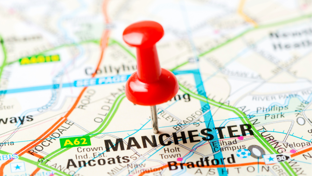 Picture of red pin in paper map on Manchester