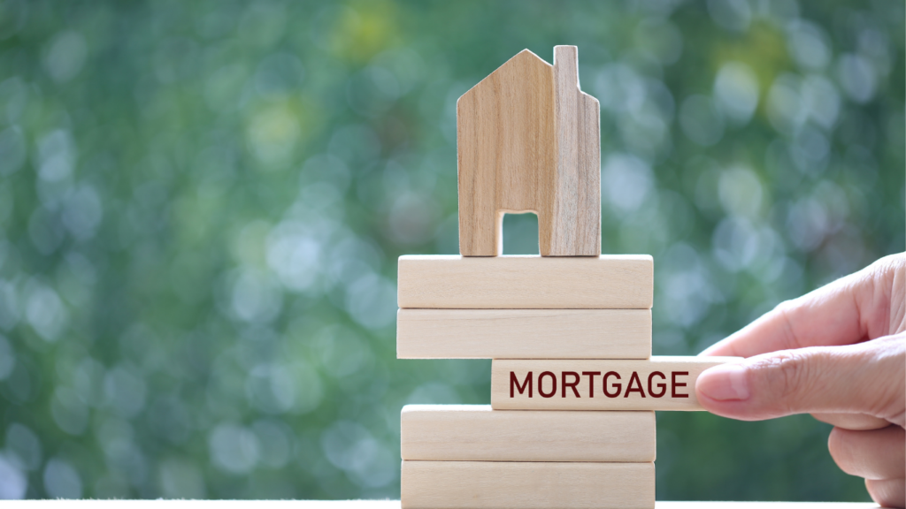 Building blocks with house on top and jenga wooden piece stating mortgage