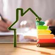 House outline with EPC ratings and person writing in the background blurred,