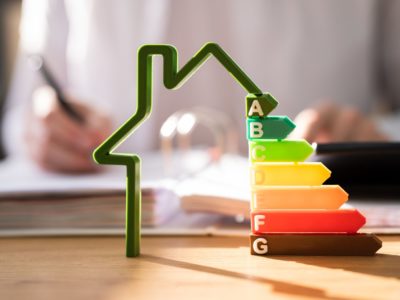 House outline with EPC ratings and person writing in the background blurred,