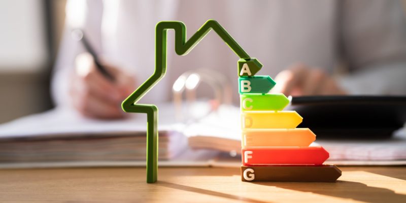 House outline with EPC ratings and person writing in the background blurred,