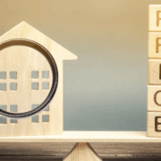 House with magnifying glass and wooden price letters