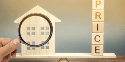 House with magnifying glass and wooden price letters