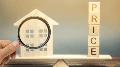 House with magnifying glass and wooden price letters