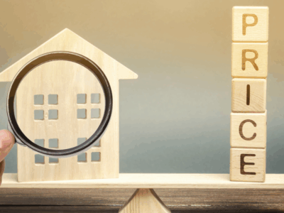 House with magnifying glass and wooden price letters