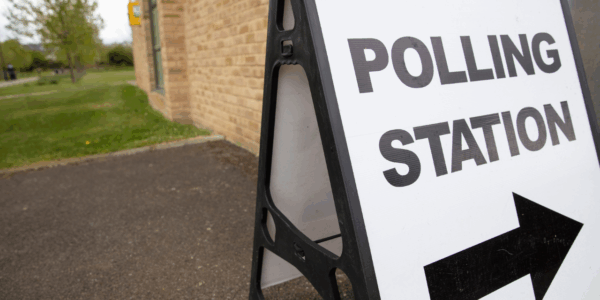 A picture of board stating polling statsion with arrow under