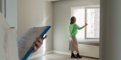 Womanin green skirt looking out the window in an empty property