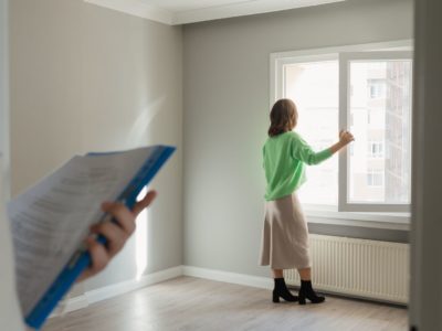 Womanin green skirt looking out the window in an empty property