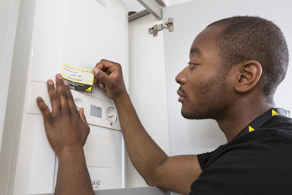 Gas engineer applying annula service sticker