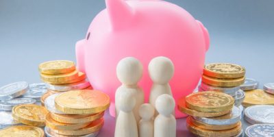 Pink piggy bank with money and figures of people