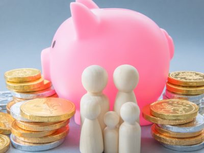Pink piggy bank with money and figures of people